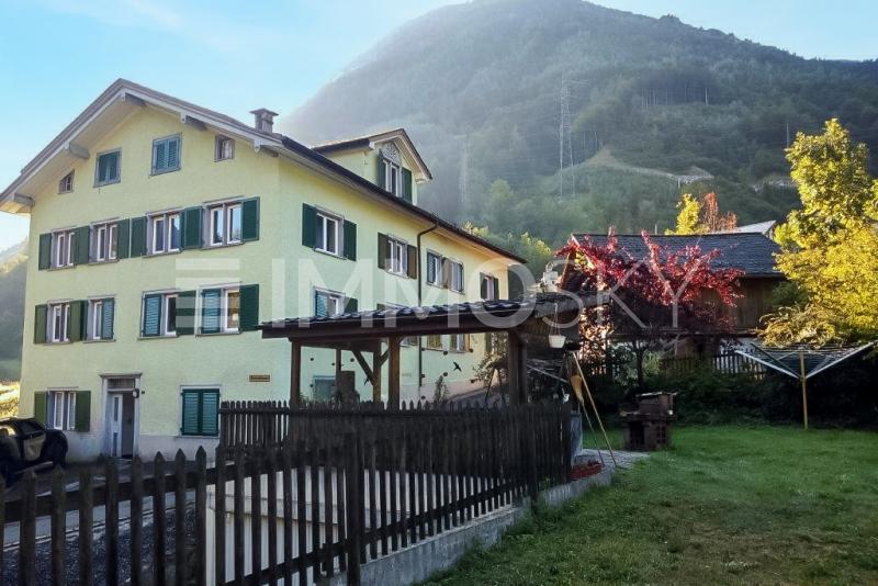 Seitenansicht mit Gemeinschaftsgarten - 20 Zimmer Mehrfamilienhaus in Schwanden GL